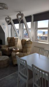 a living room with a white table and chairs at Wee Cumbrae View in Millport