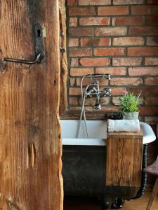 a bathroom with a sink and a brick wall at Ptasia Osada in Gardna Wielka