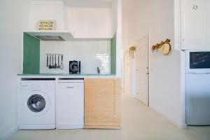 a kitchen with a washer and dryer in a room at Casa Lo-LA - Apartamento sereno y lujoso con balcón in Cala'n Bosch +8 photos