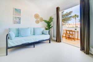 a living room with a couch and a balcony at Casa Lo-LA - Apartamento sereno y lujoso con balcón in Cala'n Bosch