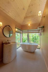 a large bathroom with a tub and a mirror at Trang An Golf and Resort 