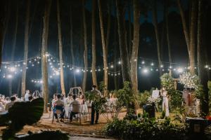 a wedding ceremony in the forest with lights at Trang An Golf and Resort 