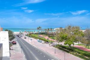a street in front of the ocean on a sunny day at Beach Walk Boutique Jumeirah in Dubai