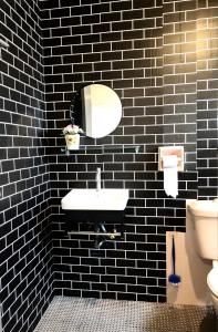 a black tiled bathroom with a sink and a mirror at Selesa hill homestay in Bentong