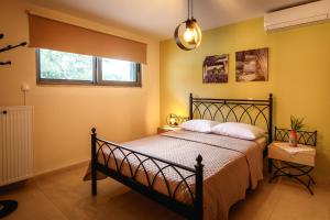 a bedroom with a bed with yellow walls at Gravaris House in Nafplio +100 photos