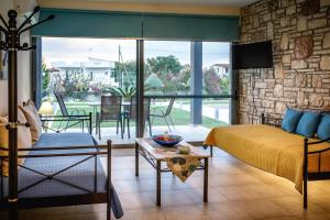 a bedroom with a bed and a living room with a tv at Gravaris House in Nafplio