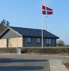 una bandera ondeando frente a una casa en Fælleshuset Kirkebakken, en Otterup