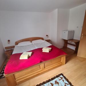 - une chambre avec un grand lit et une couverture rouge dans l'établissement Penzion Pr' Betel, à Jesenice