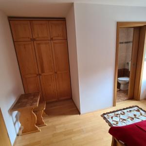 a room with a toilet and a wooden closet at Penzion Pr' Betel in Jesenice