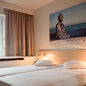 1 dormitorio con 1 cama con una estatua en la pared en Domein Martinus, en Halle