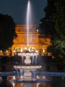 a fountain in front of a building at night at Hotel Narain Niwas Palace in Jaipur