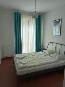 a bedroom with a large bed with green curtains at Platan 3 in Świnoujście
