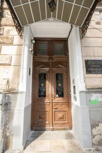 uma porta de madeira de um edifício com flores sobre ele em Barnaba Apartment em Tbilisi