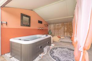 Diano San Pietro的住宿－Veggia Butega，浴缸位于带橙色墙壁的房间内