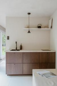 a kitchen with wooden cabinets and a sink at Cabin Water Zuidermeer in Zuidermeer