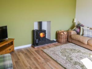 a living room with a wood stove in a living room at Low Chibburn Farm Cottage in Hadston