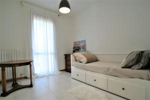 カヴァッリーノ・トレポルティにあるAppartamento - PUNTA SABBIONIのベッドルーム1室(ベッド1台、テーブル、窓付)