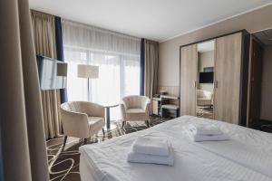 Una habitación de hotel con una cama con dos toallas. en Trofana Wellness & SPA, en Międzyzdroje