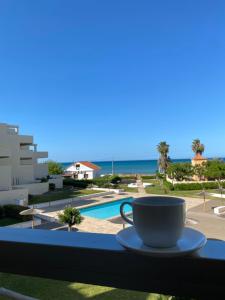 a cup of coffee on a balcony overlooking the ocean at Tierra de Mar VYBdenia in Denia