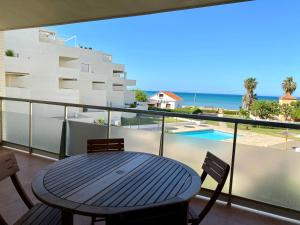 a table on a balcony with a view of the ocean at Tierra de Mar VYBdenia in Denia