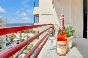 a bottle of champagne and a wine glass on a balcony at ALEXANDER APARTMENT PLAYA DE LAS AMÉRICAS in Playa de las Americas