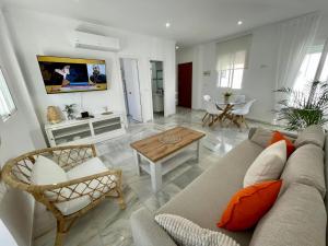 sala de estar con sofá y mesa en apartamentos la reina, en Arcos de la Frontera