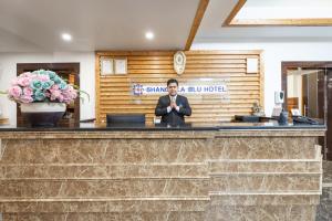 a man standing at a counter in a lobby at Shangrila Blu Hotel in Kathmandu