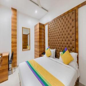 a bedroom with a large bed with a wooden headboard at Hotel Riva International Goregaon- Near NESCO in Mumbai