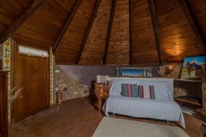 1 dormitorio con cama y techo de madera en La Pinnetta With Pool - Happy Rentals, en Codrongianos