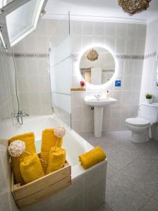 een badkamer met een bad, een toilet en een wastafel bij La Tienda de Miguel in El Chorro