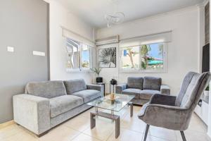 a living room with a couch and chairs and a table at Lindos Villa Ekaterina in Paralimni