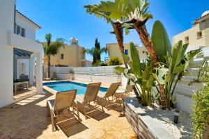 a patio with chairs and a swimming pool at Lindos Villa Ekaterina in Paralimni