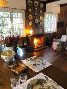 uma sala de jantar com uma mesa com copos e uma lareira em MAGNIFICA CASA DE CAMPO , CERCA DE LA PLAYA - Villa Quintueles em Cazamular