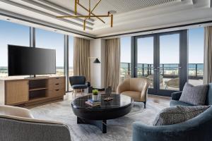 a living room with a tv and a table at JW Marriott Tampa Water Street in Tampa