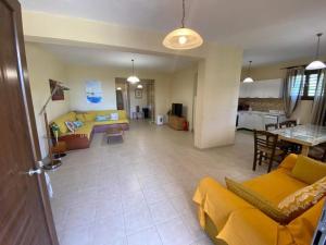 a living room with a yellow couch and a table at Athinaios Porto Klisouri Villa in Ierissos