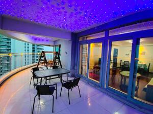 a balcony with a table and chairs and purple ceilings at Fancy Apartment in Suizhong