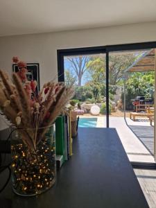 uma mesa preta com um vaso de flores e livros em Magnifique Villa avec Piscine en Provence em Verquières