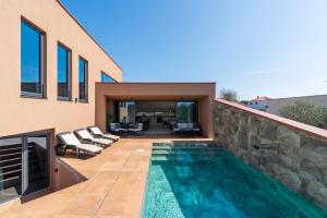 Un patio trasero con piscina y una casa. en Villa Ana, en Novigrad Istria