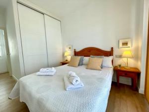um quarto com uma cama com toalhas em GATU PREMIUM Villa Poniente, junto la playa de Valdelagrana em El Puerto de Santa María