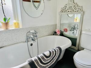 een badkamer met een bad, een toilet en een wastafel bij Larkin House in Rye