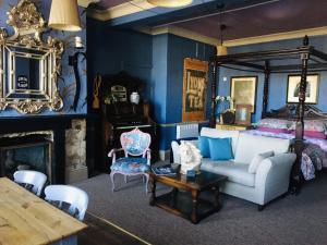 a living room with a bed and a couch and a table at The Forester and Flower in Bath