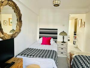 a bedroom with two beds and a mirror at Larkin House in Rye