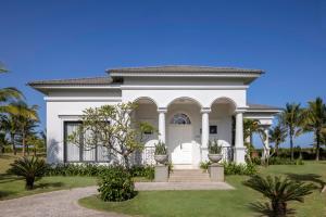 a white house with palm trees in front of it at Vinpearl Cua Hoi, Affiliated by Melia in Cửa Lò