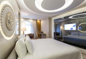 een slaapkamer met een groot bed en een televisie bij Sura Design Hotel & Suites in Istanbul