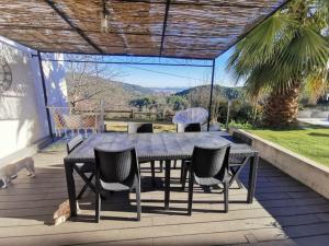 a table and chairs on a deck with a view at Villa avec vue entre Mer et Lac in Ampus