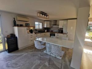 a kitchen with a large white table and chairs at Villa avec vue entre Mer et Lac in Ampus