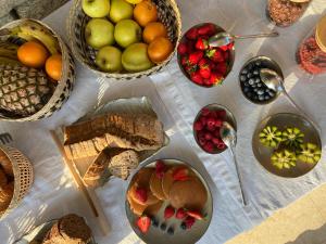 uma mesa coberta com cestos de frutas e pão em La Bastide des Salins em Saint-Tropez