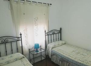1 dormitorio con 2 camas y una vela azul sobre una mesa en Dama Rural, en Posadas