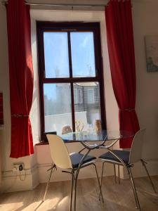 een glazen tafel en stoelen in een kamer met een raam bij Flat G/R 59 Erskine Street Aberdeen in Aberdeen