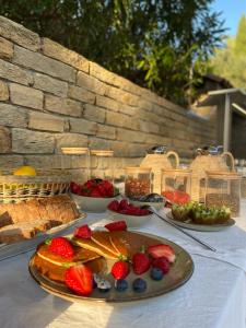 聖特羅佩的住宿－德薩蘭城堡莊園酒店，一张桌子,上面放有水果盘和糕点